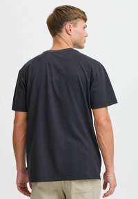 Sort bomulds t-shirt med korte ærmer, rund halsudskæring og en afslappet pasform. Enkel design uden synlige mønstre eller grafik.
