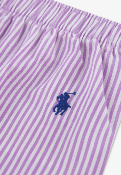 Lilla og hvide stribede stof med elastisk talje, med en blå broderet logo af en polospiller. Blød bomuldstekstur.