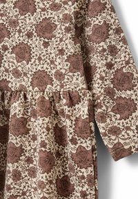 Haljina od tkanine s cvjetnim uzorkom u krem osnovi i smeškom detaljima. Ima naglašen struk i duge rukave. Tekstura laganog materijala.