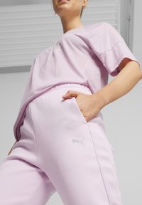 Svijetloplavi pamučni majica kratkih rukava i odgovarajuće trenerke, sa malim logotipom na lijevoj strani i bočnim džepovima na hlačama.