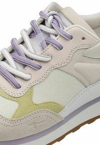 Sneaker con un design a strati, con pelle lilla chiaro e beige, rete bianca, accenti in suede verde e lacci texturizzati.