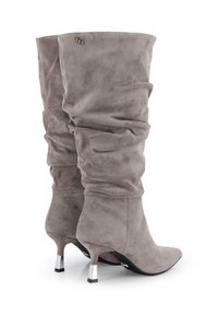 Botas de ante gris hasta la rodilla con un diseño arrugado, puntas afiladas y tacones con acentos metálicos. Textura suave con un sutil detalle en el costado.