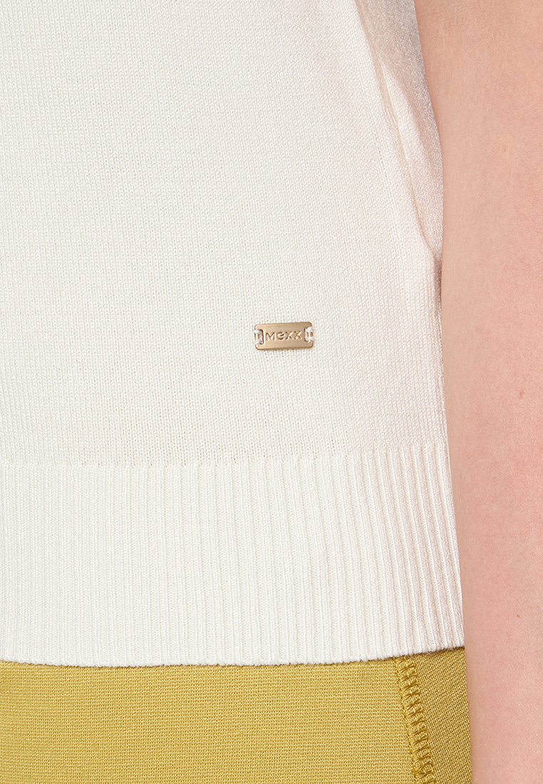 Pull en tricot blanc avec ourlet côtelé ; présente une petite étiquette logo en or. Le tissu texturé est complété par un design lisse et ajusté.