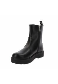 Bota de cuero negro hasta el tobillo con cremallera lateral, suela gruesa con ranuras y tira en la parte posterior contra fondo blanco.