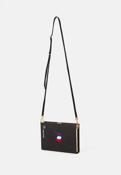 Geantă neagră rectangulară de umăr cu curea lungă și ajustabilă, accesorii aurii și broderie mică cu steagul roșu, alb și albastru pe față.