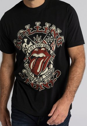Sort t-shirt i bomuld med et slidt grafisk design af røde læber og kranier, med teksten "Rolling Stones" og vintage turnédetaljer.