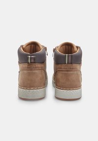 Sneakers alte marroni in pelle con accenti in tessuto grigio e suola in gomma bianca. Presentano cerniere laterali e strisce sul retro.