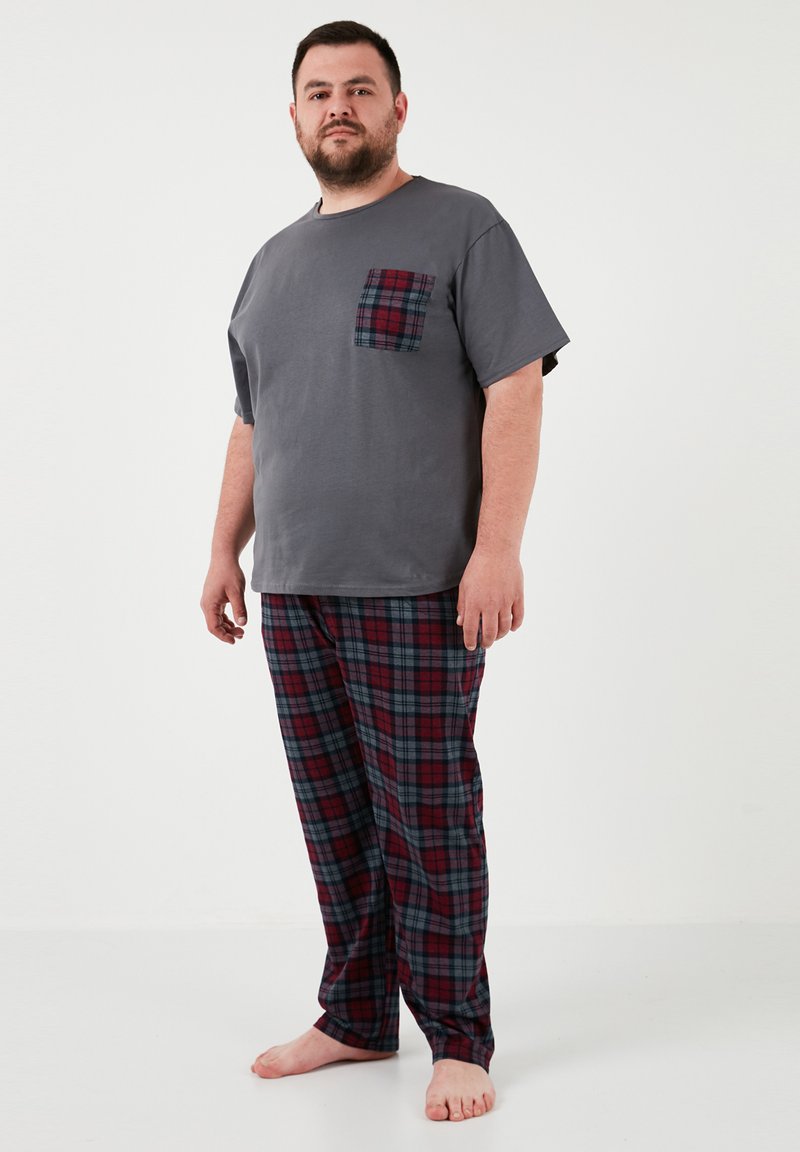 Szary t-shirt z kieszonką w kratę, zestawiony z czerwonymi i granatowymi spodniami piżamowymi w kratę, o luźnym kroju i miękkim materiale bawełnianym.