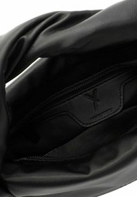 Borsa a tracolla in pelle nera con una forma morbida e non strutturata. All'interno presenta una fodera liscia e un'etichetta in pelle con un logo goffrato discreto.