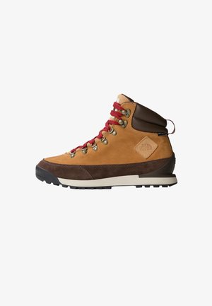 Hnedé semišové turistické topánky s červenými šnúrami, kovovými očkami, krémovým medzipodrážkou a textúrovanou podrážkou, s logom na päte.