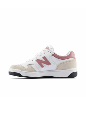 Weißer und beiger Sneaker mit pinkem "N"-Logo, weißen Schnürsenkeln und schwarzer Sohle, von der Außenseite vor weißem Hintergrund gezeigt.