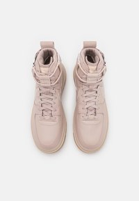 Růžové vysoké tenisky vyrobené z kůže a textilu, s tkaničkami, polstrovaným límcem a gumovou podrážkou s texturovaným povrchem.