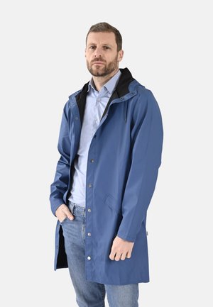 Imperméable bleu avec une capuche doublée noire, des boutons-pression et des poches. Matière légère, coupe à la longueur des hanches et coupe ample.