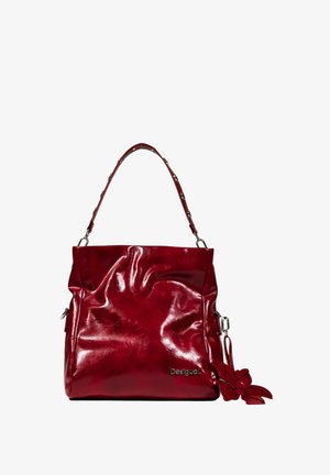 Sac à main en simili cuir rouge avec une texture froissée, une bandoulière unique et un pendentif en forme de fleur décoratif. Caractérisé par un détail de logo en argent.