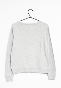Szara bluza z okrągłym dekoltem, raglanowymi rękawami i ściągaczami przy mankietach. Materiał wydaje się miękki i teksturowany, zawieszona na czarnym haczyku.