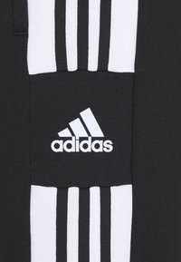 Sweat-shirt noir avec trois bandes blanches de chaque côté, portant un logo Adidas blanc brodé sur un patch à l'avant.