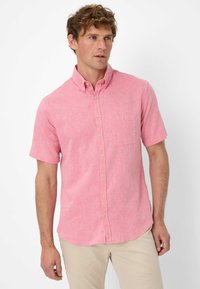 Camicia a maniche corte con bottoni in tessuto rosa chiaro dal aspetto testurizzato, dotata di una tasca frontale e bottoni beige.