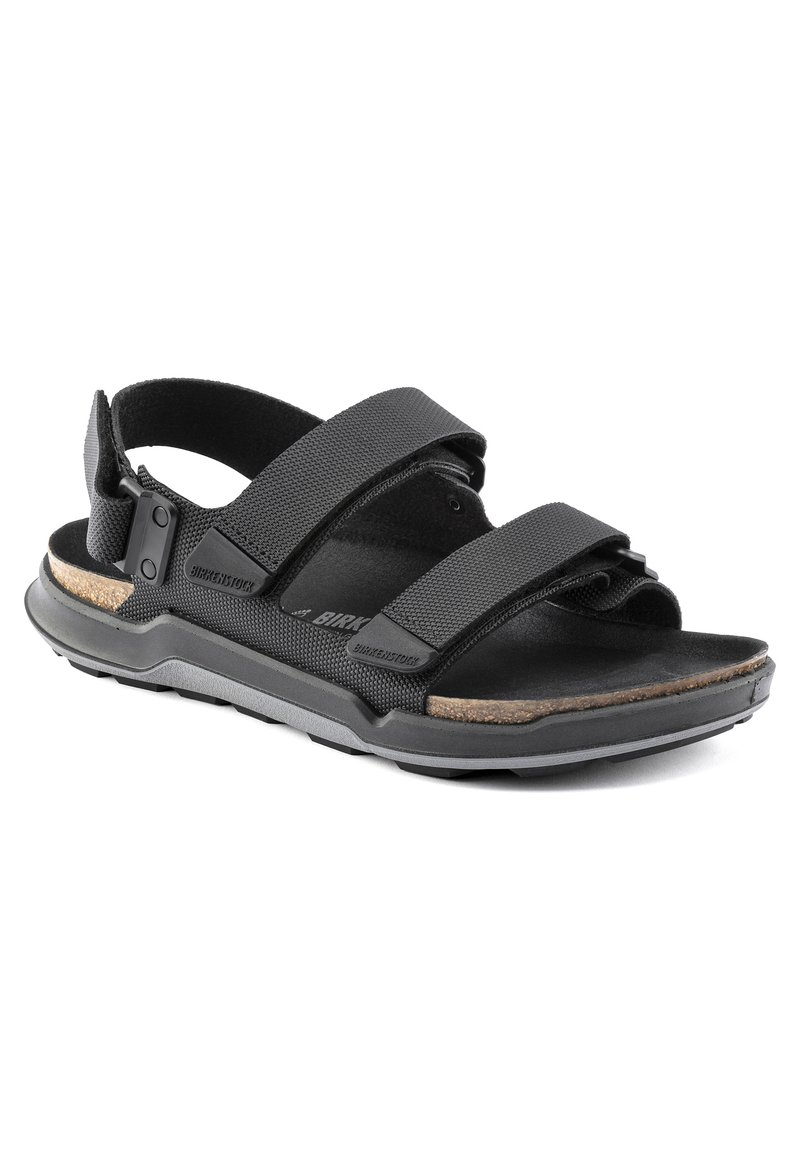 Sandale noire avec deux sangles en tissu ajustables, semelle intérieure en liège rembourrée, semelle en caoutchouc et détails texturés.