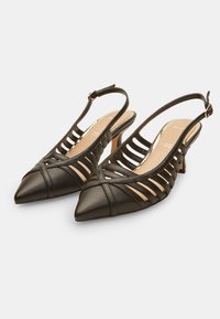 Escarpins à talons slingback en cuir noir avec bouts pointus, côtés ouverts avec un design découpé, et talon de hauteur moyenne. Texture lisse et garnitures minimales.