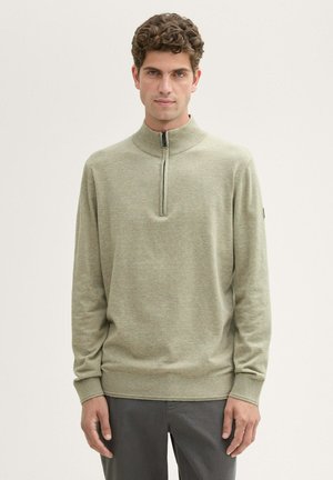  Lichtgroene, langharige pullover met een hoge kraag en een kwart-rits. Zachte textuur met geribde boorden en zoom. Minimalistisch ontwerp.