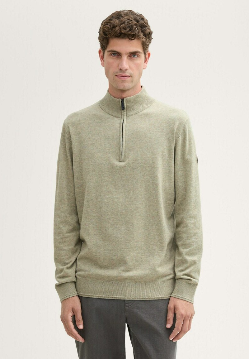 Hellgrüner, langärmeliger Pullover mit hohem Kragen und einem Viertelreißverschluss. Weicher Stoff mit gerippten Bündchen und Saum. Minimalistisches Design.