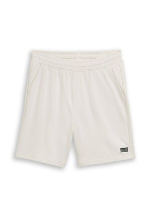 Jasnobeżowe szorty z elastycznym paskiem w talii, bocznymi kieszeniami oraz małą czarną prostokątną naszywką z logo na dolnej lewej nodze.
