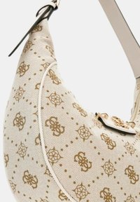 Sac hobo en toile beige avec un motif géométrique doré. Comprend un accent en métal doré et une sangle plate, de forme courbée.