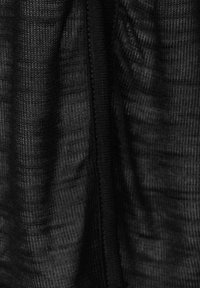 Tejido negro texturizado que muestra patrones tejidos finos y un brillo suave y sutil, con costuras visibles a lo largo de las uniones.