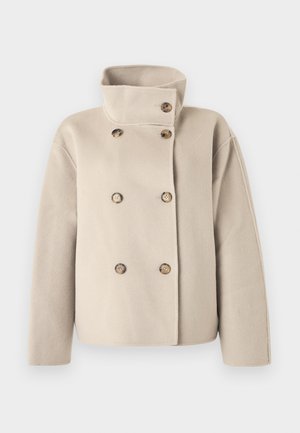 Béžový dvojradový vlnený kabát s vysokým golierom a šiestimi hnedými gombíkmi, dlhými rukávmi a širokým strihom.
