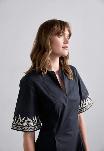 Vestido azul marino oscuro hecho de una tela suave con escote en V y patrones florales bordados decorativos en las mangas cortas.