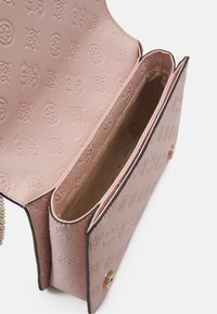 Sac bandoulière en cuir rose avec motifs géométriques embossés, rabat ouvert, intérieur en tissu beige et fermeture magnétique dorée.