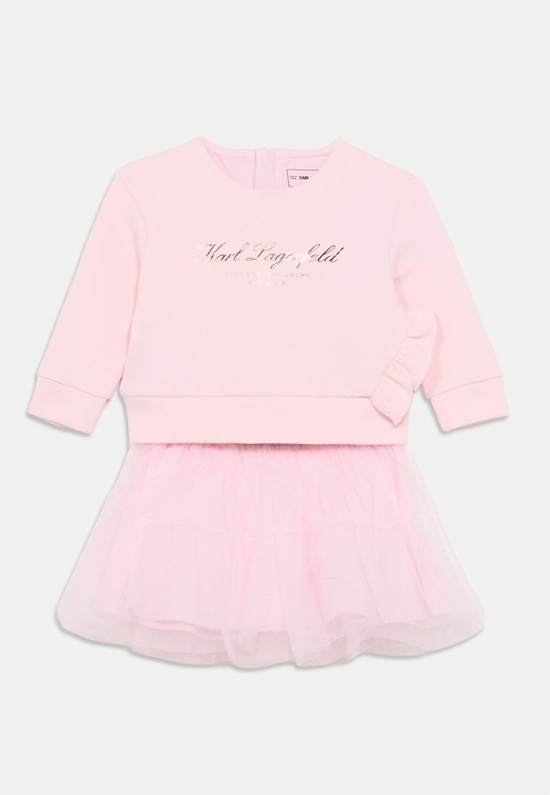 Rochie roz deschis cu top de pulover cu litere aurii, mâneci lungi și o fustă din tul stratificat pentru un efect de textură stratificată.