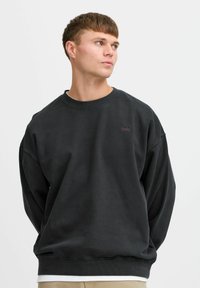 Tumehall vaba lõikega dressipluus koos soonikkoes varrukaotste ja kaeluse ning väikese tikitud logoga rinnal. Pehme, tekstureeritud kangas.