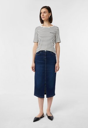 T-shirt à manches courtes rayé en blanc et bleu marine ; associé à une jupe en denim foncé arrivant au genou avec une fente devant et cinq poches. Chaussures plates noires à bout pointu.