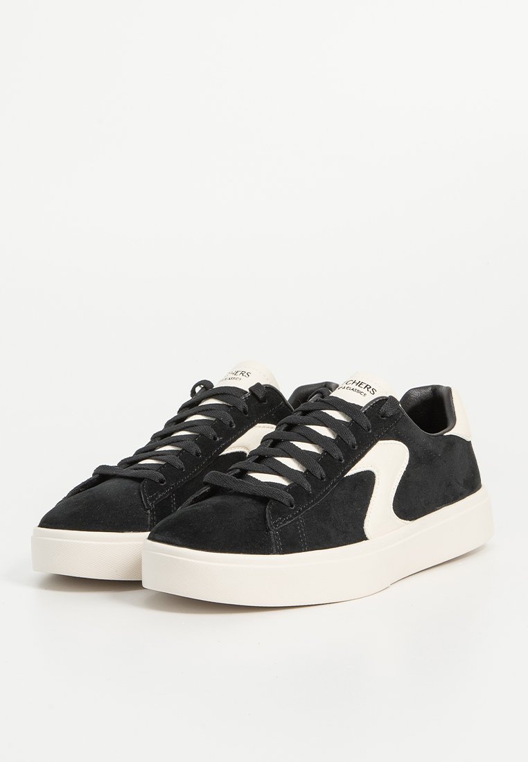 Schwarze und cremefarbene Wildledersneaker mit weißer Gummisohle, runder Zehenpartie und kontrastierendem Seitendesign. Ausgestattet mit schwarzen Schnürsenkeln und geprägtem Zungenlogo.