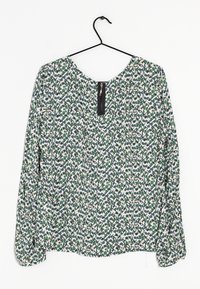Blouse à motif floral en vert, blanc et rose avec des manches longues. Présente un col rond et une fermeture éclair à l'arrière.
