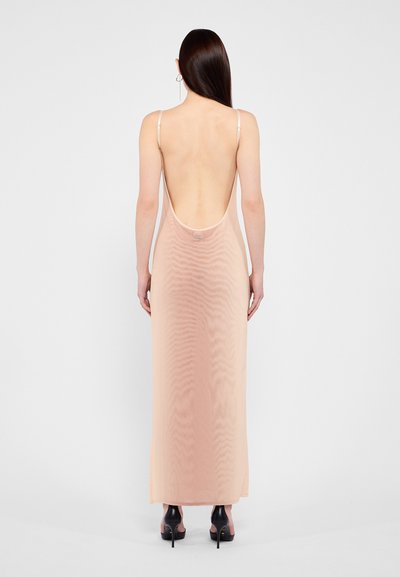 Robe longue et transparente en doux pêche avec un dos nu et des bretelles fines ajustables. Texture lisse avec un design minimal et sans motifs.