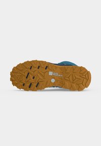 Ειδικά ανάγλυφη σόλα ορειβατικού παπουτσιού σε καφέ χρώμα με μαύρες αυλακώσεις και λογότυπο Jack Wolfskin στο κεντρικό μέρος.
