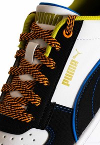 Sneaker Puma con un design bianco, nero e blu, con lacci arancioni e verdi, una parte superiore testurizzata e un dettaglio del logo ben in evidenza.