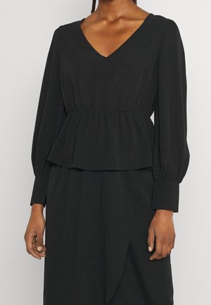 Sort bluse med V-udskæring og puffede ærmer. Har en samlede talje og glat stof, hvilket skaber en peplum-form.