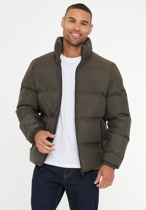 Chaqueta acolchada verde oliva con un cuello alto, puños elásticos y cierre de cremallera. Material suave y ligero con una silueta cuadrada.