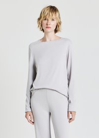 Haut gris clair à manches longues avec une texture côtelée, encolure large et poignets à bord en scallop, associé à un pantalon assorti avec des détails subtils.
