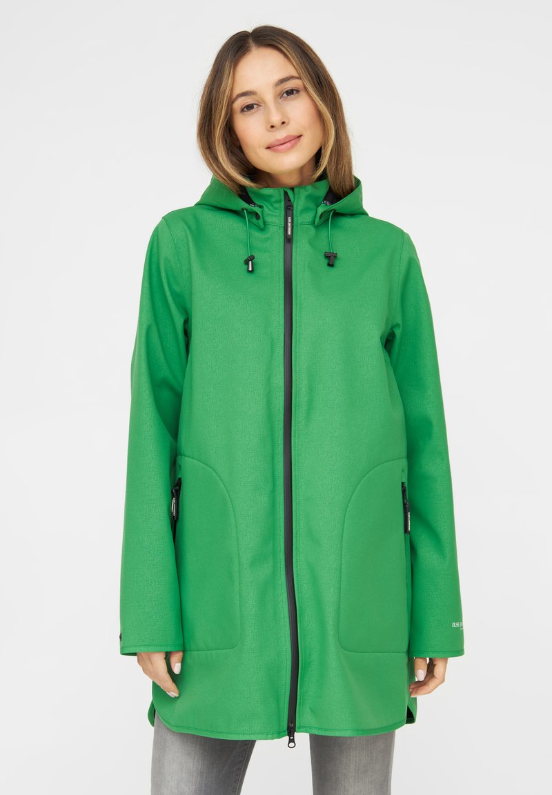 Chaqueta verde, larga, con capucha, hecha de tela texturizada. Cuenta con un cierre frontal, cordones ajustables y dos bolsillos laterales.