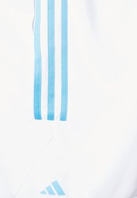 Shorts de sport blancs avec trois rayures bleu clair sur le côté et un logo bleu clair dans le coin inférieur. Texture du tissu lisse.