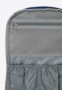 Šedá cestovní taška s police zipem z jemné síťoviny a elastickými přihrádkami, vyrobená z odolné látky s hladkou texturou.