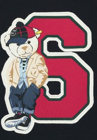 Teddybär-Graphik, die eine Jacke, ein gestreiftes Shirt und eine Mütze trägt, dazu schwarze Hosen. Das Design zeigt eine große rote "6" mit grünen Konturen auf einem schwarzen Hintergrund.
