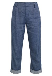 Mörkblå högmidjade denimbyxor med veck, bälteshällor och uppvikt fåll vid anklarna.