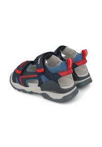Sandalias azul y marino con acentos rojos y correas de Velcro. Diseño abierto, suela texturizada y interior acolchado para mayor comodidad.
