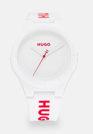 White wristwatch with red "HUGO" logo on dial and strap, red second hand, and white hour and minute hands.