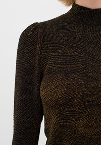 Top nero con texture e motivi ondulati dorati, caratterizzato da un collo alto e maniche a sbuffo. Tessuto morbido con una finitura leggermente lucida.